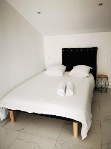 a white bed with two white pillows on it at Jaccuzzi privatif dans studio tout confort in Lachapelle-sous-Aubenas