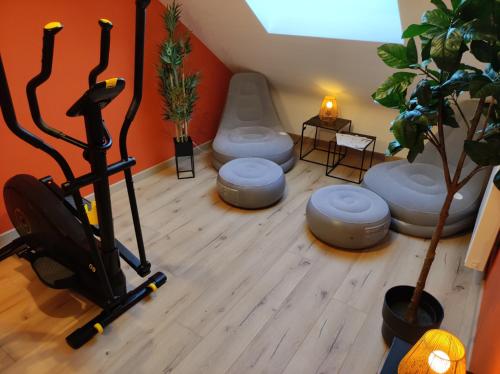 a room with a gym with a treadmill and stools at Gîte La Renéade in Foyr