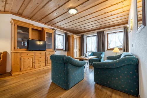 a living room with two chairs and a television at Das Geierberg in Filzmoos