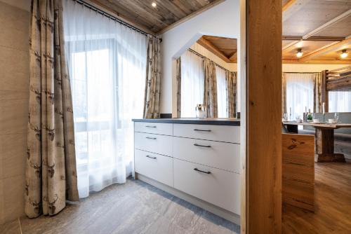 een wit dressoir in een kamer met een raam bij Das Geierberg in Filzmoos