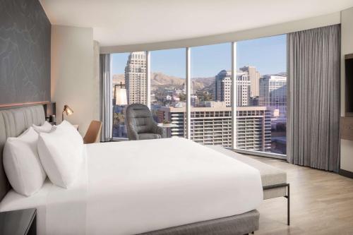 a bedroom with a large white bed and a large window at Hyatt Regency Salt Lake City in Salt Lake City