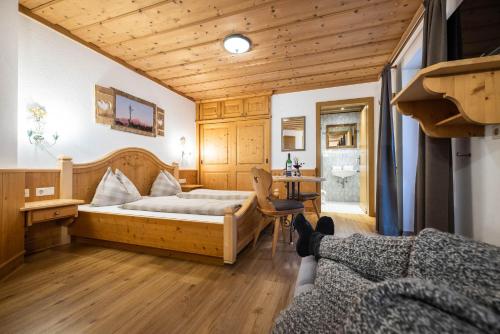 a bedroom with a bed and a desk in a room at Das Geierberg in Filzmoos