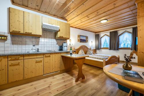 a kitchen with wooden cabinets and a table and a couch at Das Geierberg in Filzmoos