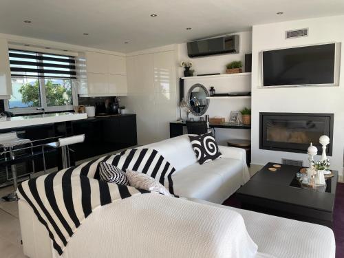 een woonkamer met een witte bank en een tv bij Sea View Luxury Studio Palaio Faliro in Athene