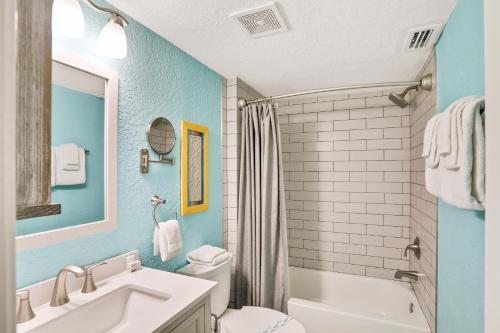 a bathroom with a sink and a toilet and a tub at Clipper Cabana Beachwalk Condo in St. Augustine
