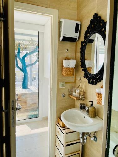 a bathroom with a sink and a mirror at Luxury Penthouse Studio with Sea View, Palaio Faliro in Athens