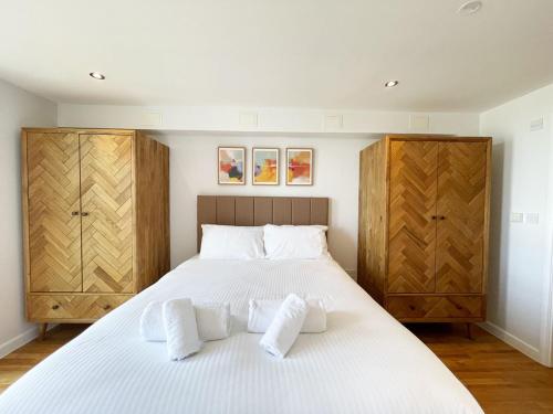 a bedroom with a large white bed with wooden cabinets at 38 Zinc in Newquay