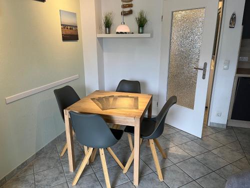 a wooden table and chairs in a room at DKK9c Ferienwohnung Ostsee-hn-sucht F in Niendorf