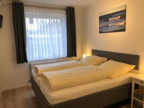 a bed in a room with a window at DKK9c Ferienwohnung Ostsee-hn-sucht F in Niendorf