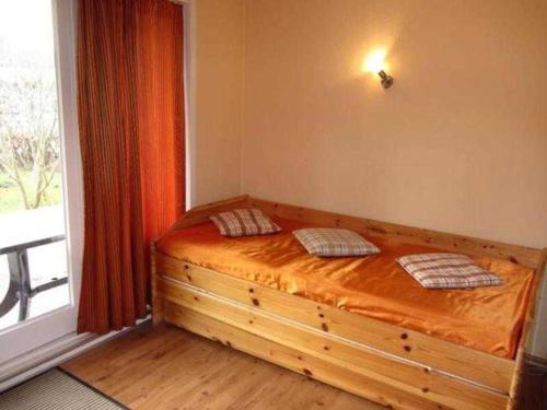 ein Schlafzimmer mit einem Holzbett und einem Fenster in der Unterkunft EIC5 Ferienhaus Schlüter in Niendorf