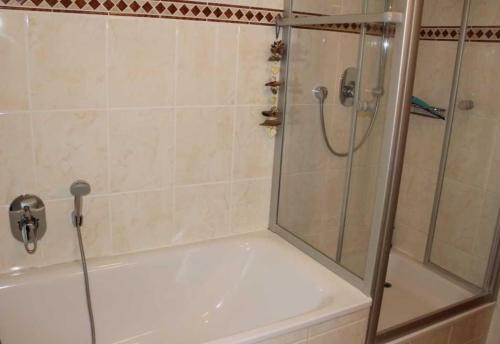 baño con ducha y bañera con puerta de cristal en BIR9b Ferienwohnung Vahle en Niendorf