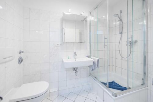 La salle de bains est pourvue d'une douche, d'un lavabo et de toilettes. dans l'établissement GAR4a Stranddüne F, à Niendorf