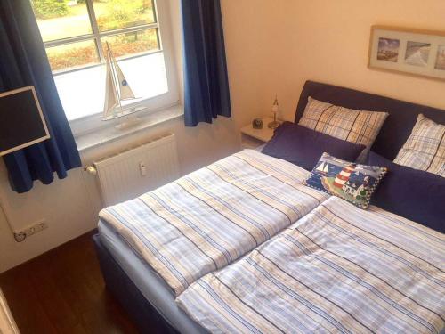 Schlafzimmer mit einem Bett und einem Fenster in der Unterkunft OST35c Ferienwohnung Sonnendeck in Niendorf