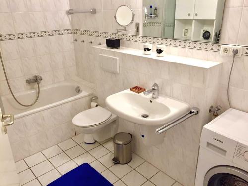 ein weißes Bad mit einem Waschbecken und einem WC in der Unterkunft OST35c Ferienwohnung Sonnendeck in Niendorf