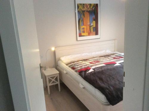 um quarto com uma cama com uma fotografia na parede em ROD32a Ferienwohnung Muschelfischer F em Niendorf