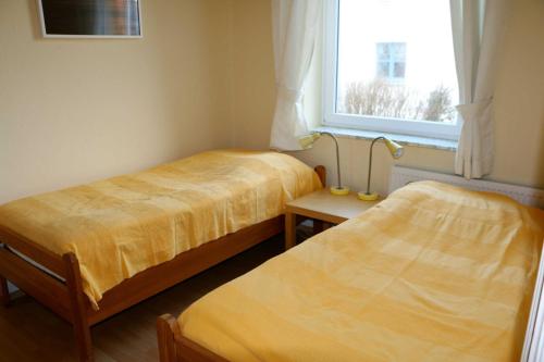 2 Betten in einem Zimmer mit Fenster in der Unterkunft STR81b Ferienwohnungen Steinmetz - Landseite in Niendorf