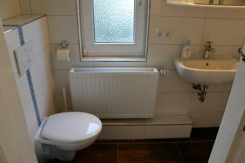 ein kleines Bad mit WC und Waschbecken in der Unterkunft STR81b Ferienwohnungen Steinmetz - Landseite in Niendorf
