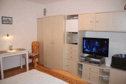 un soggiorno con TV e scrivania di STR90b Haus Diana a Niendorf