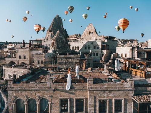a group of hot air balloons flying over a city at Sultan Cave Suites in Göreme