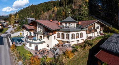 eine Luftansicht eines großen Hauses auf einem Hügel in der Unterkunft Das Geierberg in Filzmoos