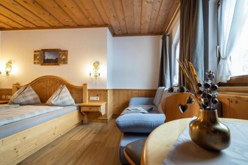 a bedroom with a bed and a couch and a table at Das Geierberg in Filzmoos