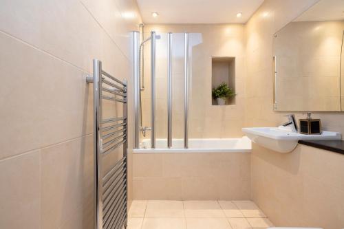 y baño con ducha y lavamanos. en ALTIDO Luxury 2BR home on George Street, en Edimburgo