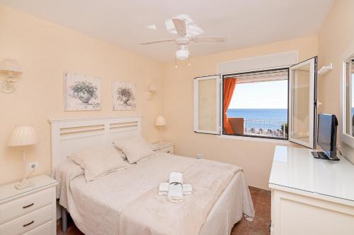 een slaapkamer met een bed en een raam met uitzicht op de oceaan bij Bhost - The King in Fuengirola