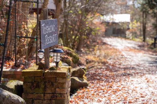 um sinal sentado numa parede de pedra ao lado de uma estrada em TOSHINO RESORT Nikko em Nikko