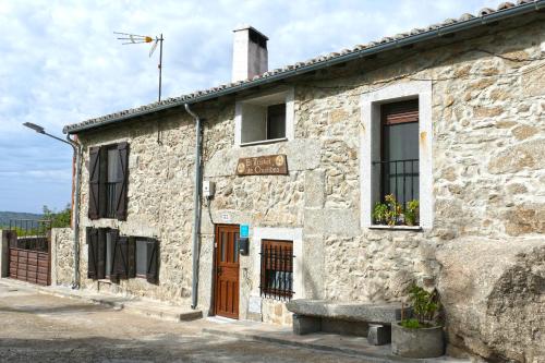 een oud stenen gebouw met een bank ervoor bij El Triskel de Chumbea, alojamiento excepcional con maravillosas vistas a 5km de Béjar in Navalmoral de Béjar