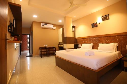 a hotel room with a bed and a kitchen at HOTEL SOUTHERN HERITAGE in Udupi