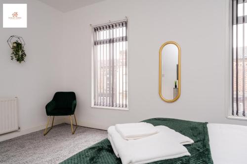 a bedroom with a bed and a mirror and a chair at Immaculate 4 bed in Liverpool By Hinkley Homes Short Lets & Serviced Accommodation in Liverpool