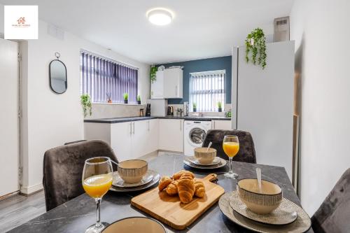a kitchen with a table with bread and wine glasses at Immaculate 4 bed in Liverpool By Hinkley Homes Short Lets & Serviced Accommodation in Liverpool