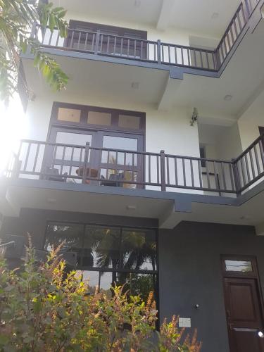 a large house with a balcony on top of it at Waves Hiri Sea View in Hiriketiya