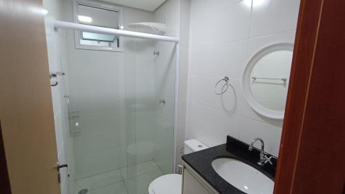 a bathroom with a shower and a sink and a toilet at Apartamento Resort Palmeiras 2 com 03 Quartos Ubatuba in Ubatuba