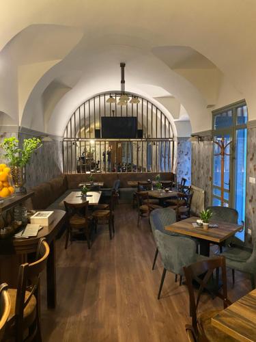 a dining room with tables and chairs and a tv at Centrum Panzió in Mohács