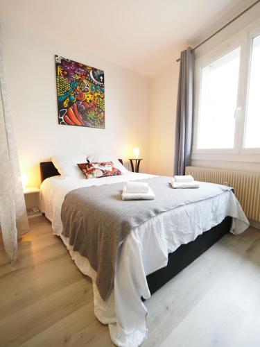 - une chambre avec un lit et 2 serviettes dans l'établissement LE CALLOU - Parking - Face aux Thermes - Rez de Chaussée, à Vichy
