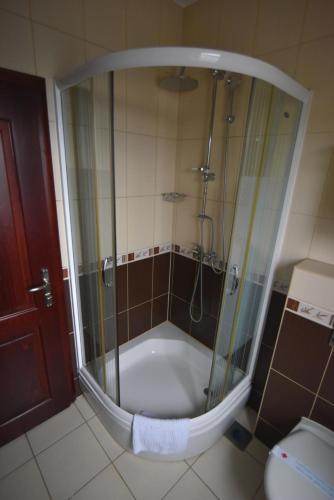 a bathroom with a shower and a bath tub with a toilet at Motel Atlantis in Prijedor