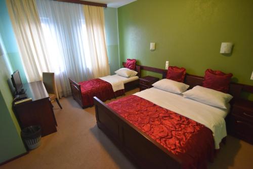 two beds in a room with green walls at Motel Atlantis in Prijedor