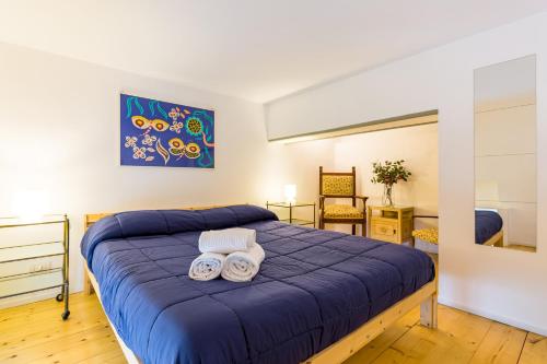 1 dormitorio con 1 cama azul y 2 toallas en Grifeo - Quiet and Relaxing Flat on Panoramic Route en Nápoles