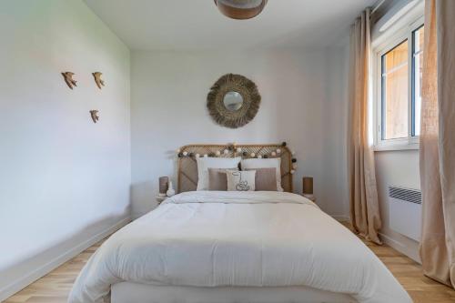 a white bedroom with a large bed and a window at Nagaya - Petit nid avec terrasse à 100m du bassin in La Teste-de-Buch