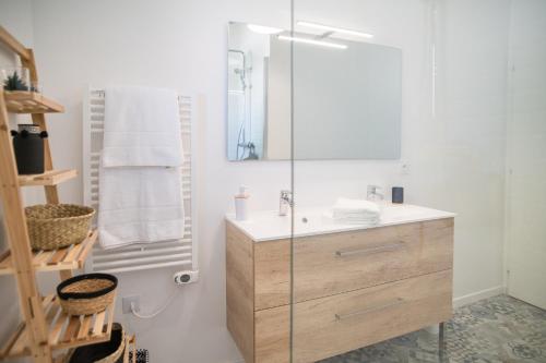 łazienka z umywalką i przeszkloną kabiną prysznicową w obiekcie Villa Nina- Maison cocon cosy w mieście La Teste-de-Buch