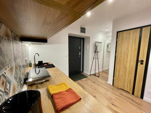 Habitación con cocina con barra y puerta. en Przestronny apartament w centrum miasta, en Radom