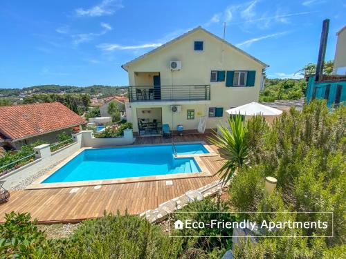 une villa avec une piscine et une maison dans l'établissement Eco Sunshine Apartments Lumbarda, à Lumbarda