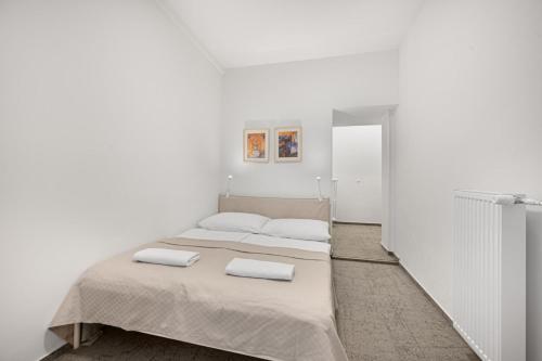 two beds in a room with white walls at Pension Petit in Bratislava