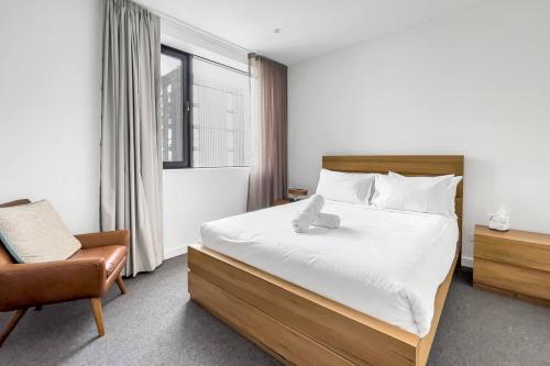1 dormitorio con 1 cama, 1 silla y 1 ventana en Modern 2 Bedroom in the Heart of Bondi Junction, en Sídney