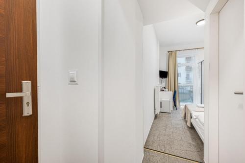 a room with a hallway with a bed and a door at Pension Petit in Bratislava
