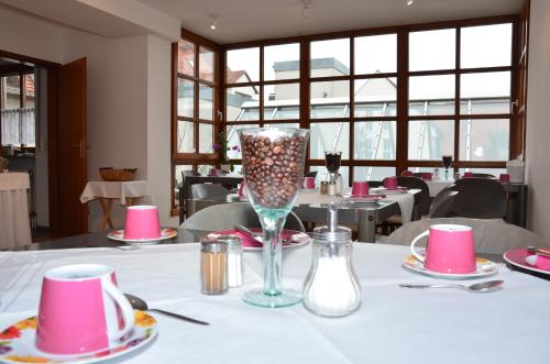 a table with a glass vase on a table in a restaurant at Hotel zum Brunnen in Friedberg