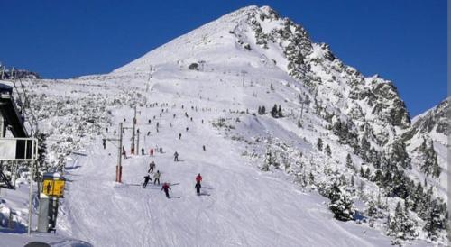 een groep mensen die skiën op een met sneeuw bedekte berg bij Apartment Tatry Hiking & Wellness in Veľká Lomnica