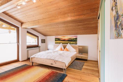 a bedroom with a bed and a wooden ceiling at Landhaus Aggenstein in Haldensee