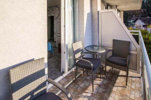 een patio met stoelen en een tafel op een balkon bij Hotel Villa Harmony in Sarajevo